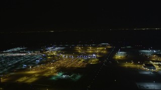 5K aerial stock footage track a small plane landing at Oakland International Airport, Oakland, California, night Aerial Stock Footage | AXSF07_100