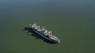 AXSF08_037 - 5K aerial stock footage tilt from Suisun Bay, reveal National Defense Reserve Fleet warship, Suisun Bay, California