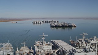 AXSF08_039 - 5K aerial stock footage tilt from Suisun Bay, reveal National Defense Reserve Fleet warships, Suisun Bay, California