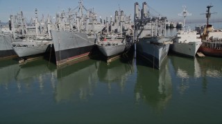 AXSF08_040 - 5K aerial stock footage tilt from Suisun Bay, reveal and orbit National Defense Reserve Fleet, California