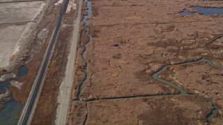 AXSF08_057 - 5K aerial stock footage of flying away from railroad tracks, country road beside marshlands, Martinez, California