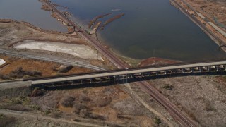 5K aerial stock footage of flying away from railroad tracks, marshlands, Martinez, California Aerial Stock Footage | AXSF08_059