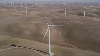 5K aerial stock footage tilt from small hills, reveal Shiloh Wind Power Plant windmills, Montezuma Hills, California Aerial Stock Footage | AXSF08_065