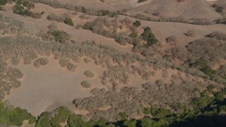 AXSF09_007 - 5K aerial stock footage of a reverse view of brown hills and green trees at Briones Regional Park, Martinez, California