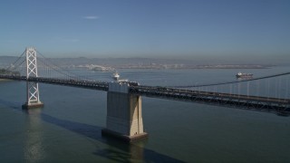 5K aerial stock footage fly over the Bay Bridge to reveal a cargo ship, San Francisco, California Aerial Stock Footage | AXSF09_056