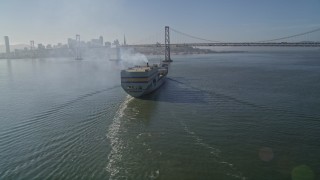 5K aerial stock footage track a cargo ship approaching the Bay Bridge, San Francisco, California Aerial Stock Footage | AXSF09_058