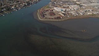 5K aerial stock footage of flying away from warehouse buildings by the Oakland Estuary and over San Leandro Bay, Oakland, California Aerial Stock Footage | AXSF09_072