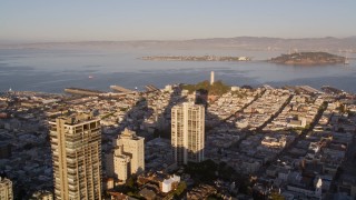 AXSF10_004 - 5K aerial stock footage of a view of Coit Tower while flying by Russian Hill high-rises, San Francisco, California, sunset