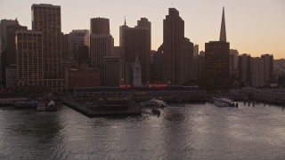 5K aerial stock footage tilt from the bay to reveal the Ferry Building and Downtown San Francisco skyscrapers, California, sunset Aerial Stock Footage | AXSF10_069