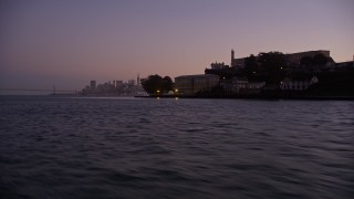 AXSF10_087 - 5K aerial stock footage fly low by Alcatraz to reveal skyline of Downtown San Francisco, California, twilight