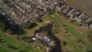 5K aerial stock footage fly away from suburban homes and golf course to reveal Hayward Executive Airport, California Aerial Stock Footage | AXSF11_003