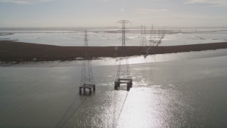 AXSF11_025 - 5K aerial stock footage tilt from marshland and follow power lines through wetlands, Sunnyvale, California