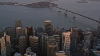 5K aerial stock footage tilt from city skyscrapers to reveal Bay Bridge, Downtown San Francisco, California, sunset Aerial Stock Footage | AXSF14_026