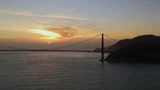 5K aerial stock footage Golden Gate Bridge with setting sun in the distance, San Francisco, California, sunset Aerial Stock Footage | AXSF14_039