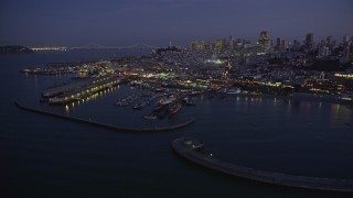 AXSF14_087 - 5K aerial stock footage of flying by iconic Fisherman's Wharf, San Francisco, California, twilight