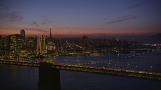 5K aerial stock footage flying by the Bay Bridge with San Francisco skyline in the background, California, night Aerial Stock Footage | AXSF14_113