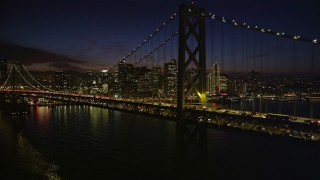 5K aerial stock footage flying by the Bay Bridge with the skyline in background, Downtown San Francisco, California, night Aerial Stock Footage | AXSF14_127