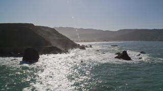 AXSF15_040 - 5K aerial stock footage of tilting from the ocean revealing coastal cliffs and rock formations, Pacifica, California