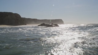 AXSF15_061 - 5K aerial stock footage of flying low near cliffs and ocean rock formations, Half Moon Bay, California