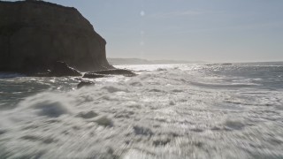 AXSF15_062 - 5K aerial stock footage of flying low over ocean waves near cliffs in Half Moon Bay, California