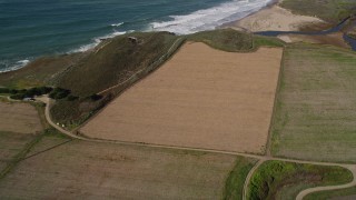 5K aerial stock footage of a reverse view of farm fields on the coast, Santa Cruz, California Aerial Stock Footage | AXSF15_088