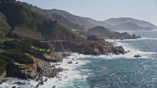 AXSF16_063 - 5K aerial stock footage of flying by waves crashing against jagged coastline, reveal Highway 1, Carmel, California