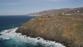 5K aerial stock footage of flying away from the Point Sur Light Station on coastal cliffs, Big Sur, California Aerial Stock Footage | AXSF16_086