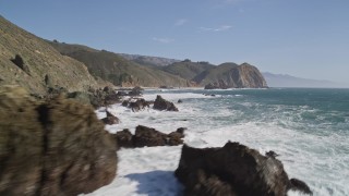 5K aerial stock footage tilt from ocean to reveal coastal rock formations below cliffs, Big Sur, California Aerial Stock Footage | AXSF16_100