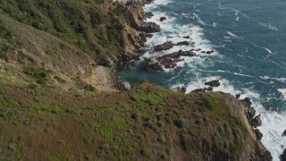 5K aerial stock footage tilt from waves crashing and approach cliffs on the coast, then tilt back down to the water, Big Sur, California Aerial Stock Footage | AXSF16_117