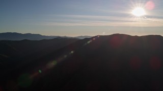 5K aerial stock footage of flying by a mountain range with the sun overhead, San Luis Obispo County, California Aerial Stock Footage | AXSF17_026