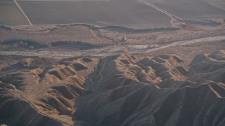 5K aerial stock footage of a reverse view of a dry riverbed and Caliente Range mountains, Cuyama Valley, California Aerial Stock Footage | AXSF17_032