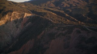 AXSF17_057 - 5K aerial stock footage tilt up mountainside to a road, Los Padres National Forest, California, sunset