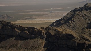 HD stock footage aerial video flyby mountain to reveal tower at Ivanpah Solar Electric Generating System, Mojave Desert, California Aerial Stock Footage | CAP_005_008