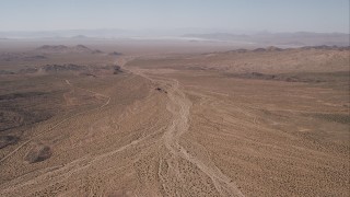 HD stock footage aerial video of a dirt road by an arid valley, Mojave Desert, California Aerial Stock Footage | CAP_005_022