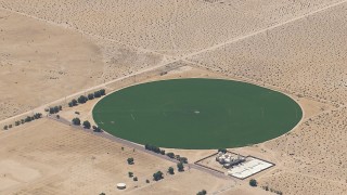 CAP_006_022 - HD stock footage aerial video of a crop field beside a Mojave Desert monastery in Newberry Springs, California