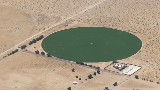 HD stock footage aerial video of a reverse view of a crop field beside a Mojave Desert monastery in Newberry Springs, California Aerial Stock Footage | CAP_006_023