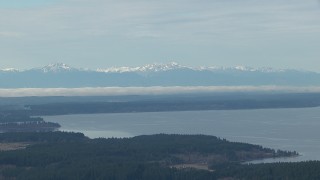 HD stock footage aerial video of the snowy Olympic Mountain range seen from Puget Sound, Washington Aerial Stock Footage | CAP_009_007