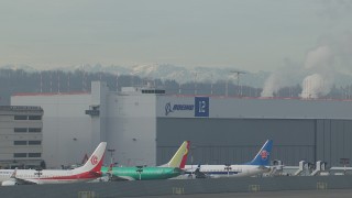 HD stock footage aerial video flyby commercial jet and zoom in on a hangar at Boeing Field, Washington Aerial Stock Footage | CAP_009_043