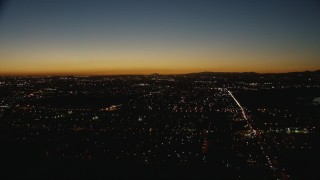 HD stock footage aerial video tilt from residential neighborhoods to reveal the Downtown Los Angeles city skyline at twilight, California Aerial Stock Footage | CAP_010_008