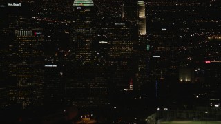 HD stock footage aerial video tilt from Downtown Los Angeles city buildings to Figueroa and Wilshire skyscraper at night, California Aerial Stock Footage | CAP_010_014