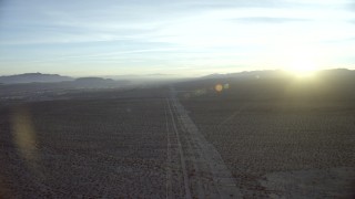 HD stock footage aerial video of following power lines through the desert to approach Daggett, California at sunrise Aerial Stock Footage | CAP_011_001