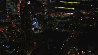 HD stock footage aerial video of a Ferris wheel at nighttime while passing skyscrapers, Downtown Atlanta, Georgia Aerial Stock Footage | CAP_013_064