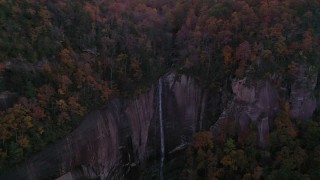 CAP_014_019 - 2.7K stock footage aerial video a reverse view of forest and a clifftop waterfall at sunset, Chimney Rock, North Carolina