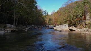 CAP_014_029 - 2.7K stock footage aerial video flying low over the river surrounded by forest trees, Chimney Rock, North Carolina