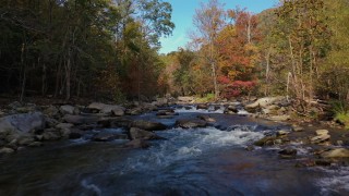 CAP_014_030 - 2.7K stock footage aerial video flying low over rocks and water in the river surrounded by forest trees, Chimney Rock, North Carolina