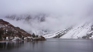 CAP_015_005 - 4K stock footage aerial video of flying low over a lake toward snowy mountain slopes, Inyo National Forest, California