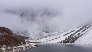 CAP_015_007 - 4K stock footage aerial video of a reverse view of Ellery Lake and snowy mountain slopes, Inyo National Forest, California