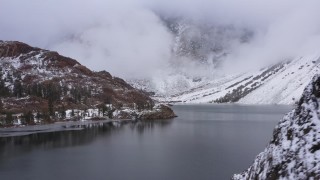 CAP_015_012 - 4K stock footage aerial video passing snowy mountain slopes to reveal the lake, Inyo National Forest, California