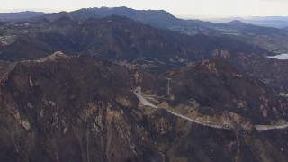 HD stock footage aerial video of passing road and tunnels by mountains scarred by fire, Malibu, California Aerial Stock Footage | CAP_018_017