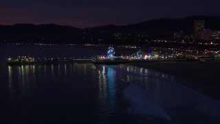 HD stock footage aerial video approach Ferris wheel and rides at night, Santa Monica Pier, California Aerial Stock Footage | CAP_018_112